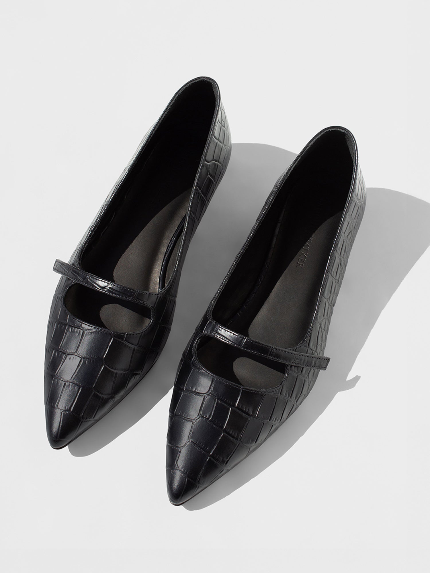 Pair of black croc-embossed Mary Jane flats with pointed toes and slim front straps