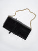 Black crocodile leather shoulder pochette with a gold chain strap, laid flat on a light gray background