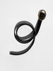 Black croc-embossed leather belt coiled to show its full length and oval gold buckle