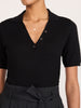 Isola dress in black onyx, close-up of buttoned polo collar and pleated tie-waist detail