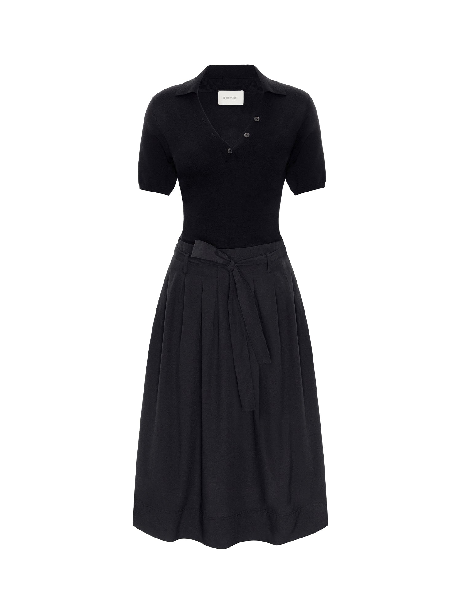 Isola dress in black onyx, a knit polo-style top with a pleated skirt and tied waist belt, shown on a white background.