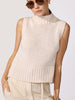 Knitted turtleneck tank top in blush chunky rib knit with a high neck, sleeveless fit, and peplum hem worn with cream drawstring trousers.