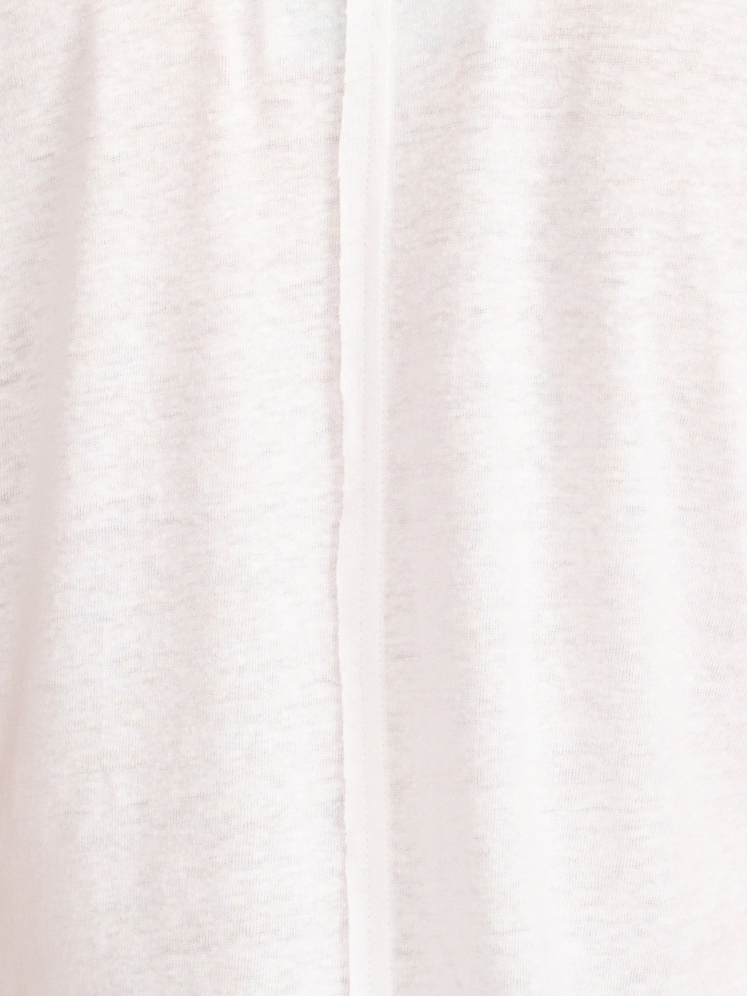 Close-up fabric detail of the white Koda tee showing its lightweight slub-knit texture and center seam.