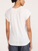 Back view of a model in the white Koda short sleeve tee styled with indigo jeans.