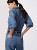 Women's denim outfit shown from the back featuring a medium-wash cropped shirt with puff sleeves and matching wide-leg trousers with elastic waist.