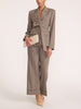 Belted blazer and wide-leg trouser suit in gravel melange gray, full-length view with cream clutch and beige heels
