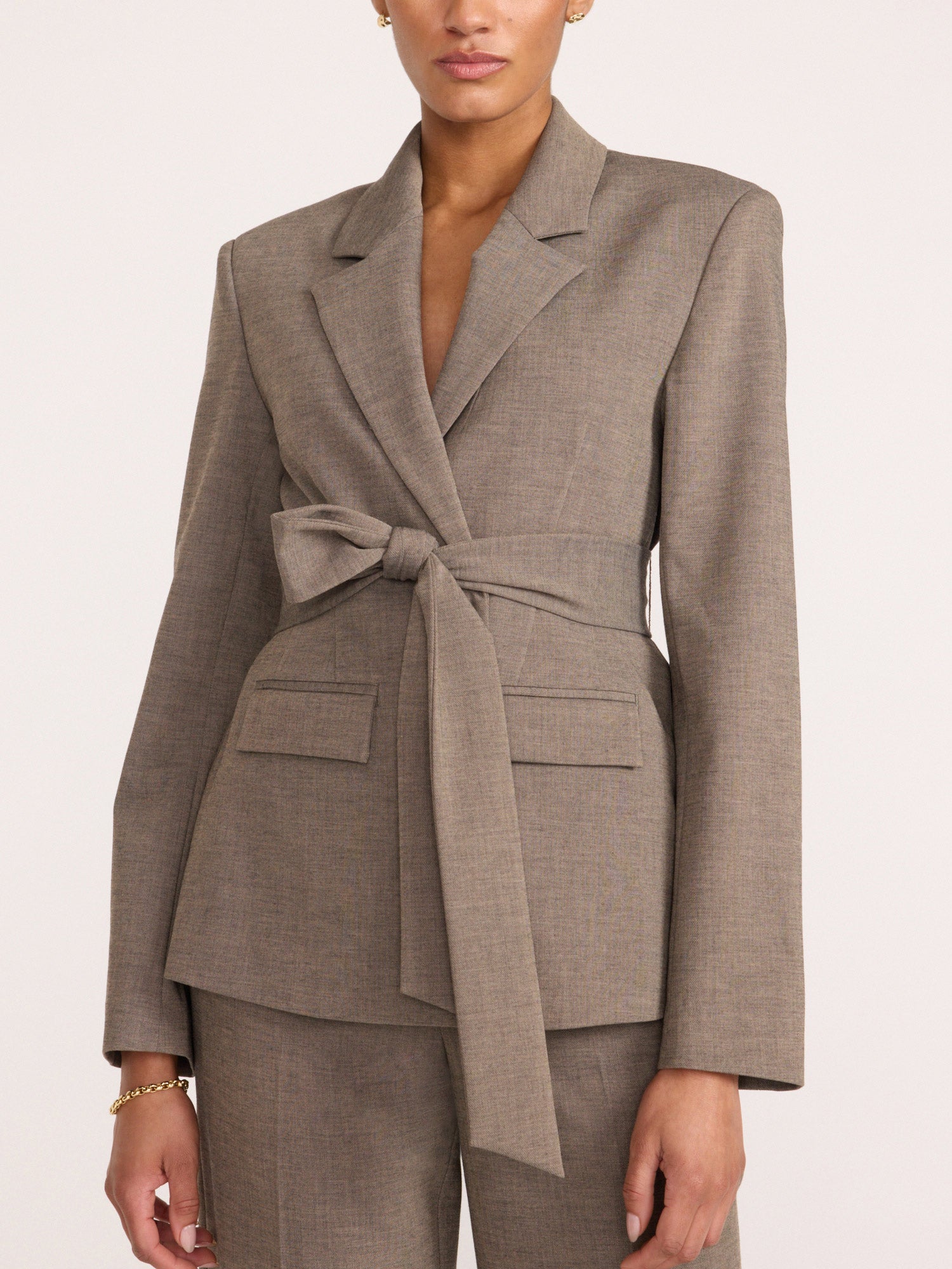 Belted blazer and trouser suit in gravel melange gray, close-up front view with tie-waist and flap pockets