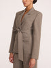 Belted blazer and trouser suit in gravel melange gray, side profile view with tie-waist detail