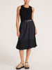 Full-length outfit featuring the black Leo Tank, a black leather wrap belt, and a black eyelet-hem midi skirt with tan platform sandals.