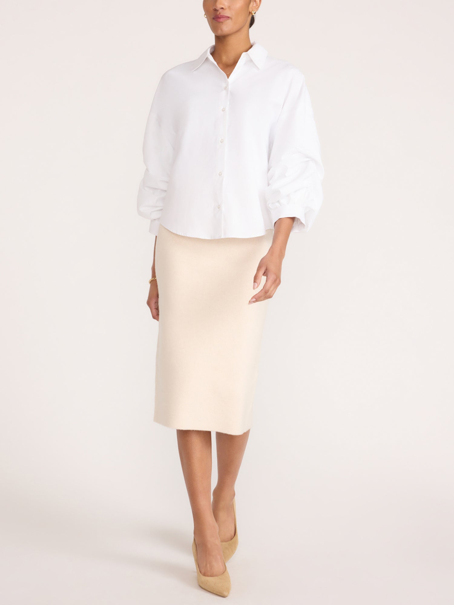 White long-sleeve button-up shirt, styled with a beige midi skirt and pointed-toe heels
