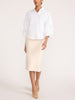 White long-sleeve button-up shirt, styled with a beige midi skirt and pointed-toe heels