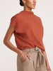 Morten funnel-neck cashmere top in canyon orange melange, styled with beige tie-waist trousers
