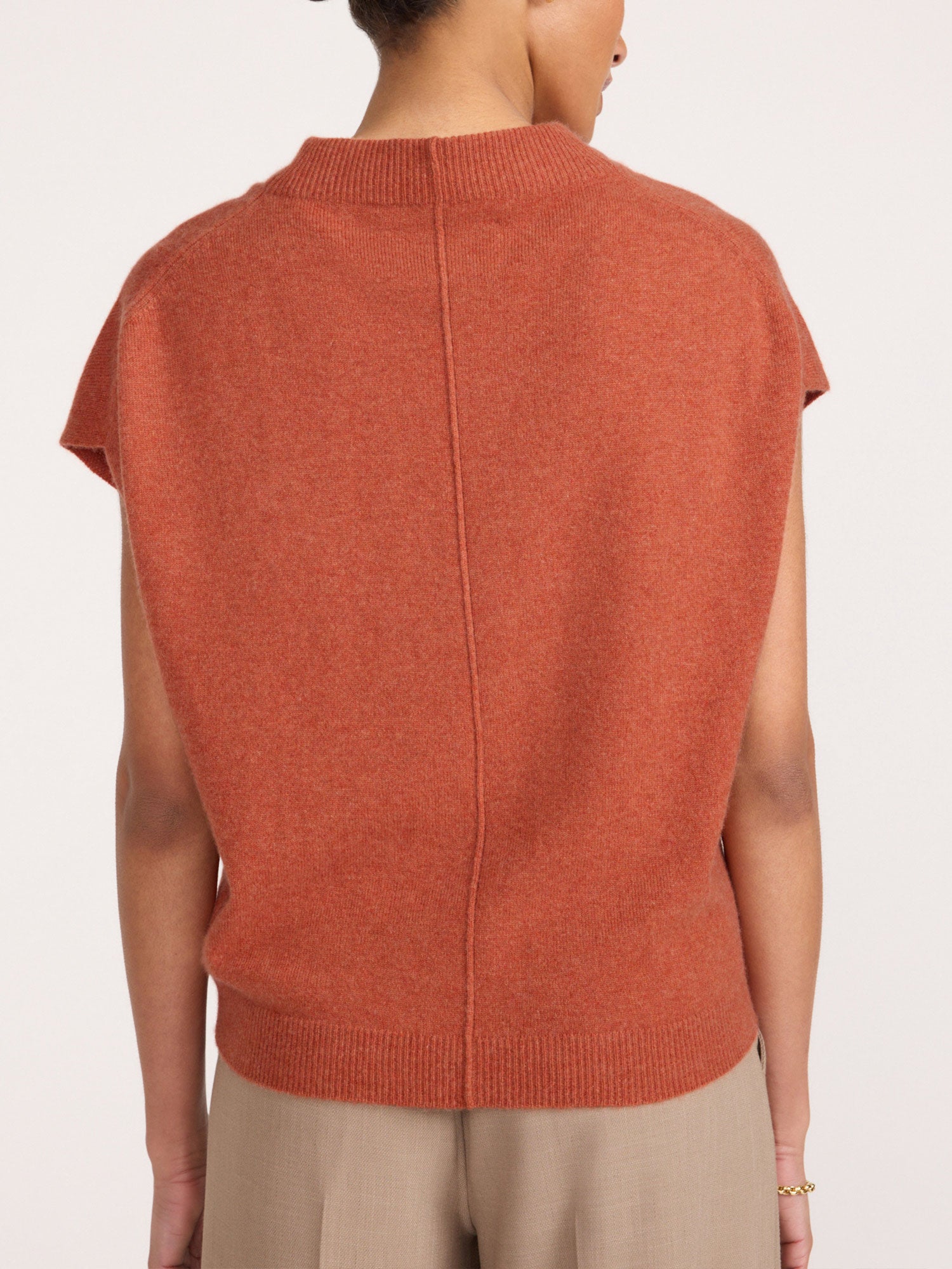 Morten funnel-neck cashmere top in canyon orange melange, back view with beige trousers