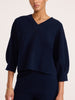 Front view of a women's navy blue V-neck knit top with three-quarter balloon sleeves and matching pants