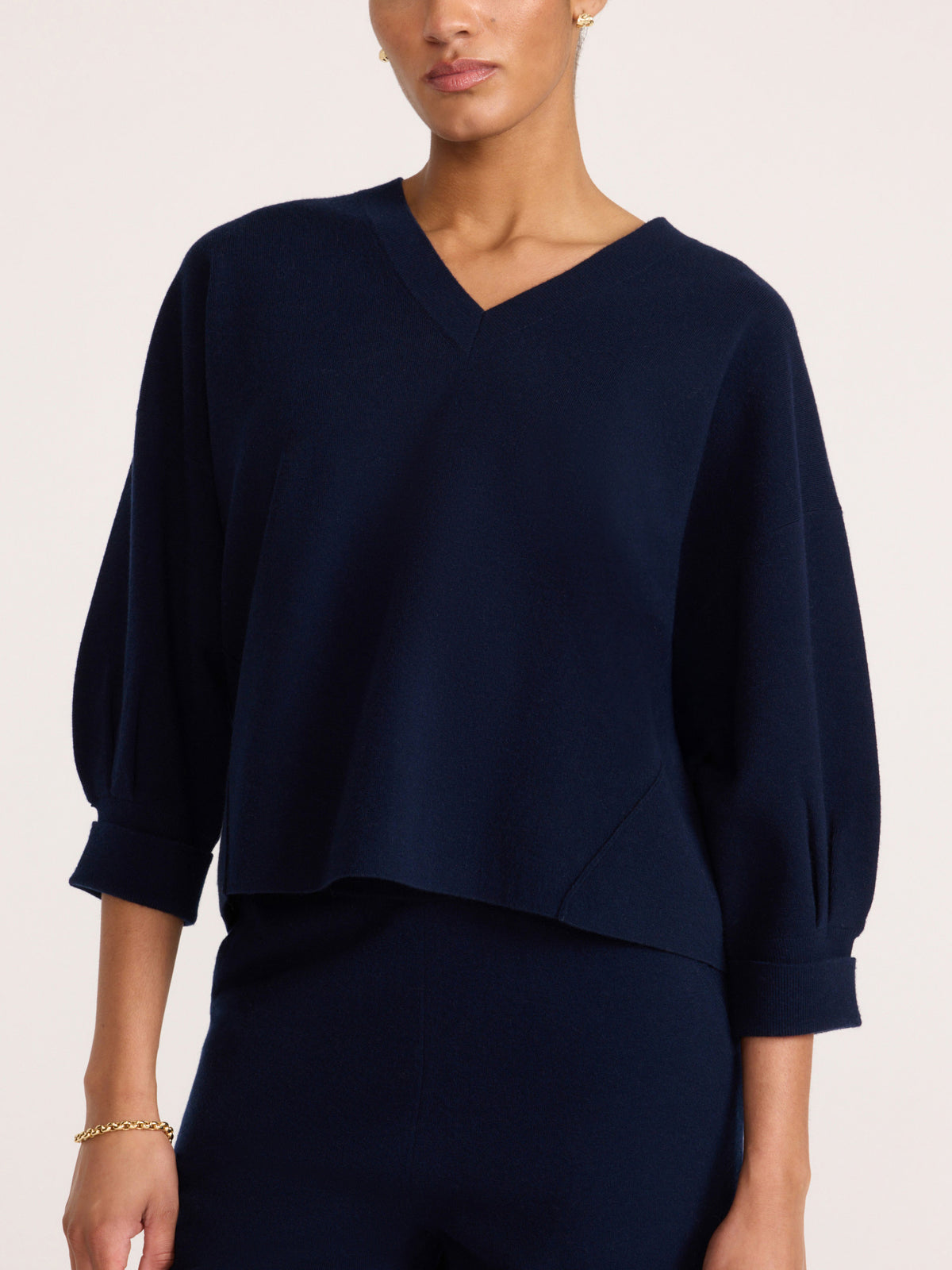 Front view of a women's navy blue V-neck knit top with three-quarter balloon sleeves and matching pants