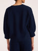 Back view of a women's navy blue V-neck knit sweater with three-quarter balloon sleeves