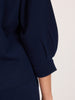 Close-up of a women's navy blue V-neck sweater sleeve with a ribbed cuff