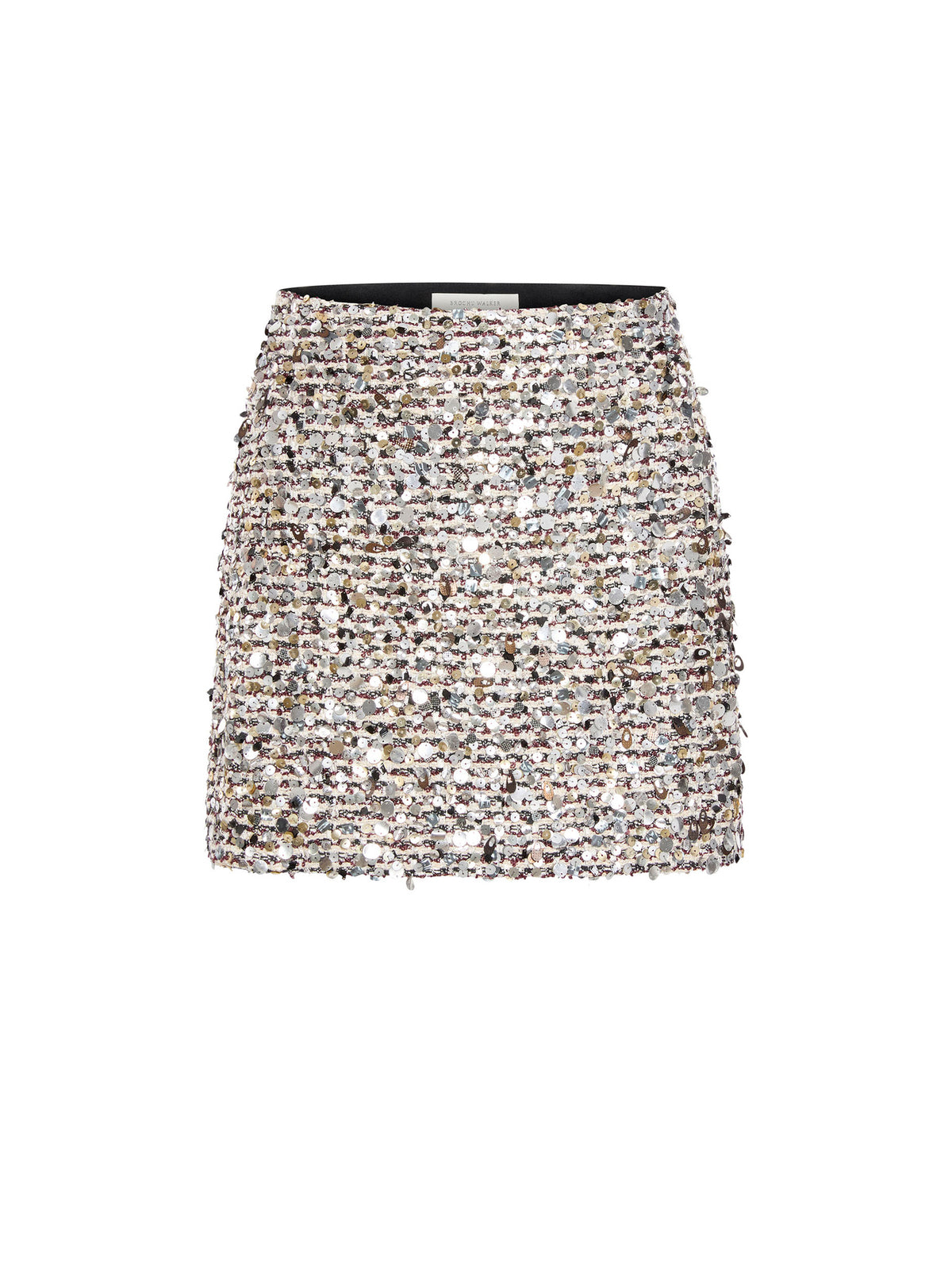 Front view of a women's tweed mini skirt with a black fuzzy sweater, a gold bracelet and black Mary Jane flats