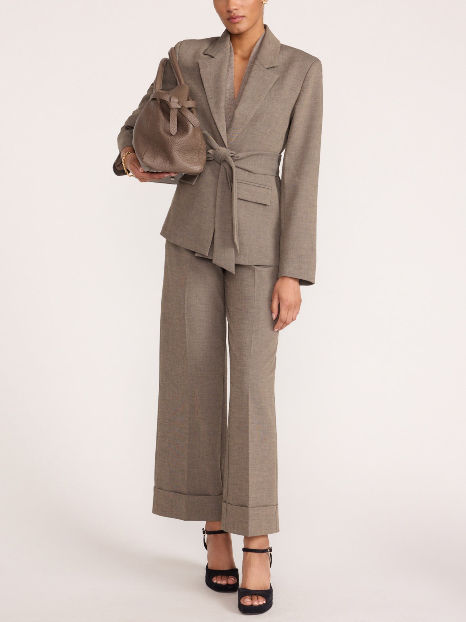 Wide-leg trousers in gravel melange gray, styled with a matching belted blazer and taupe leather bucket bag