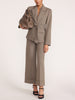 Wide-leg trousers in gravel melange gray, styled with a matching belted blazer and taupe leather bucket bag