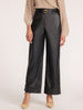Women's black wide-leg vegan leather cropped pants with rolled cuff, styled with a belt and heels