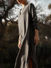 Voile kaftan dress in brownstone, long loose-fitting linen dress with split hem, outdoor garden setting at dusk