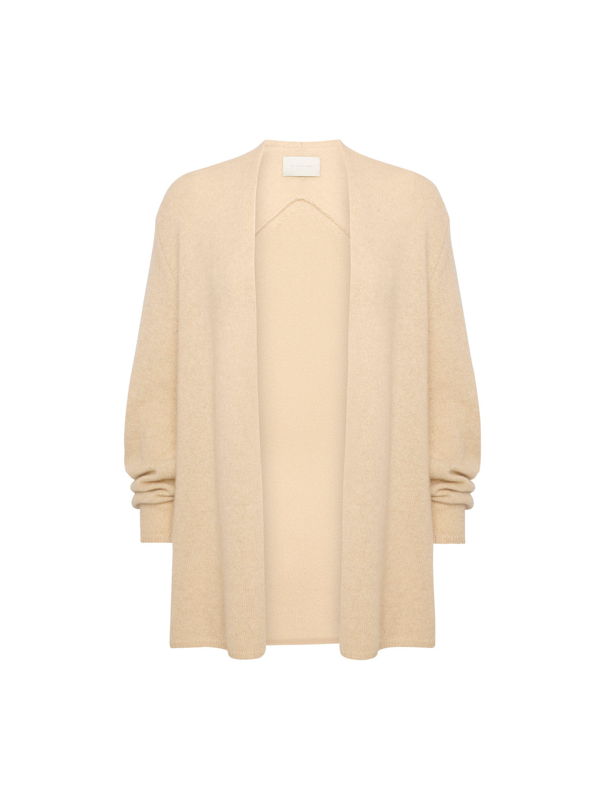 Woman wearing a cream wrap cardigan over an ivory ribbed turtleneck with a gold buckle belt and cream trousers