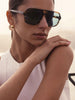 Woman wearing The Cassis Sunglasses, tortoiseshell aviator vintage sunglasses, resting her chin on her hand