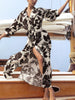 Woman wearing The Kate Printed Maxi Dress, a black-and-white floral maxi dress, on a sailboat deck