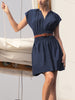 Short-sleeve mini dress in navy, styled with a brown belt on a sailboat