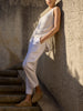 Morrow sleeveless knit top and cropped trousers in white, full-length view against a stone wall