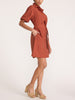 Side view of a woman wearing the Villa dress in Tuscany, a collared shirt dress with beige platform sandals.