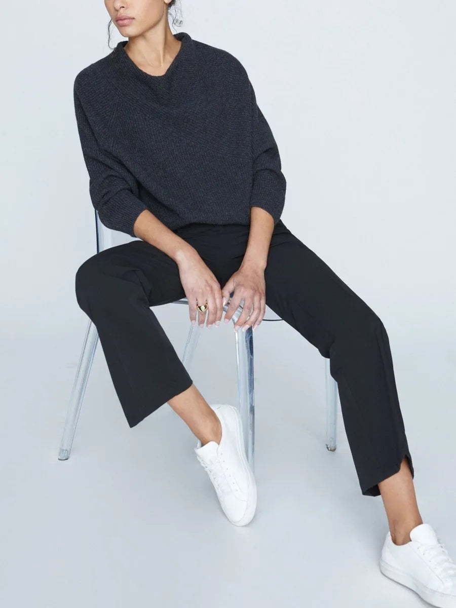 Charcoal ribbed cashmere sweater with cowl neck, styled with black pants and white sneakers.