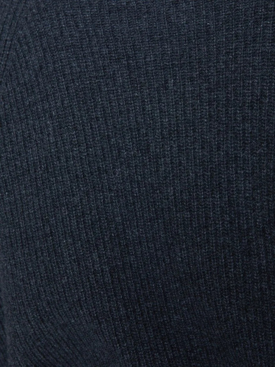 Close-up of dark charcoal ribbed knit fabric showing the cashmere sweater's multi-directional rib stitch texture.