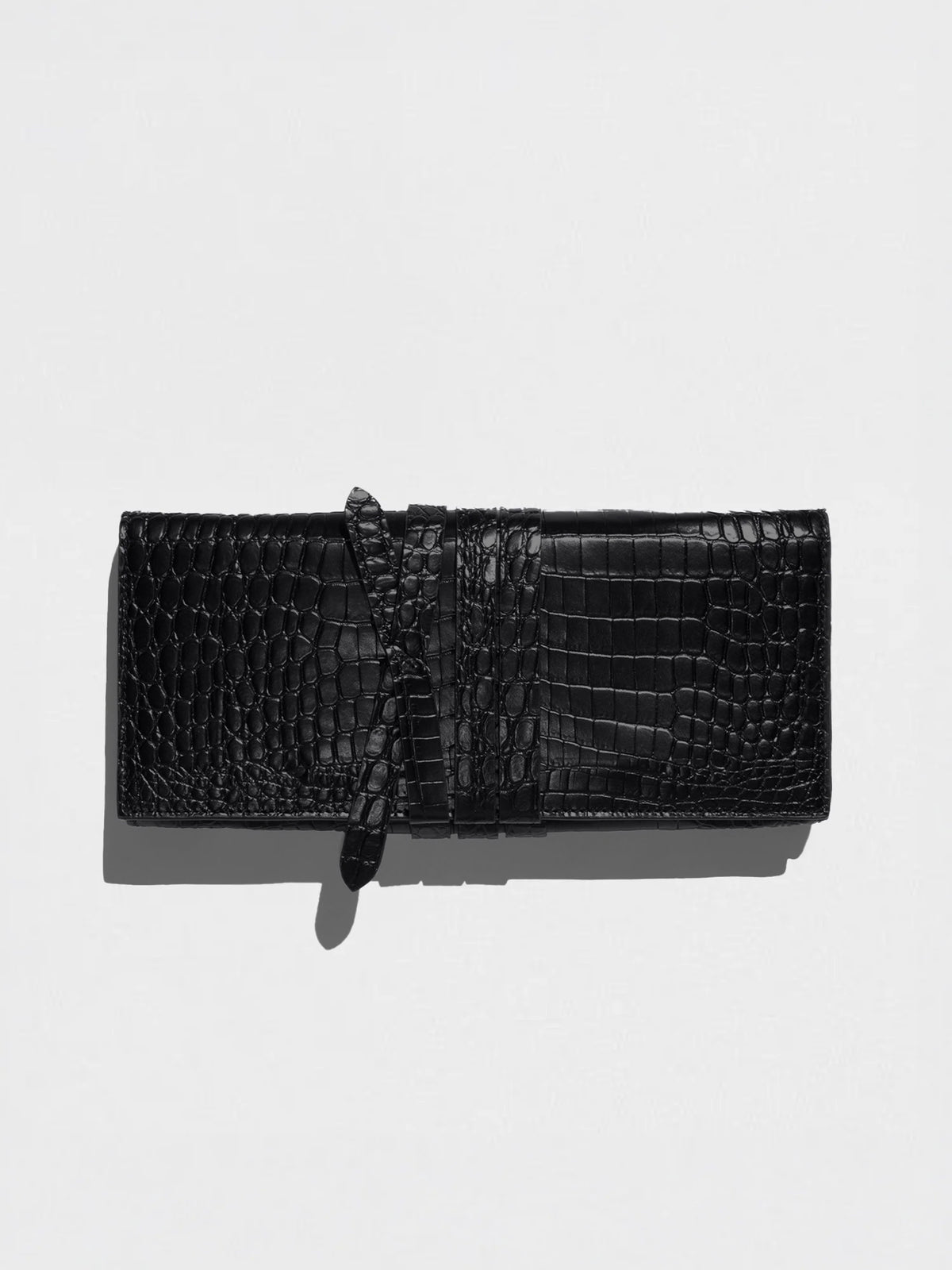 Black crocodile leather shoulder pochette with a wraparound tie strap, shown flat on a light gray background