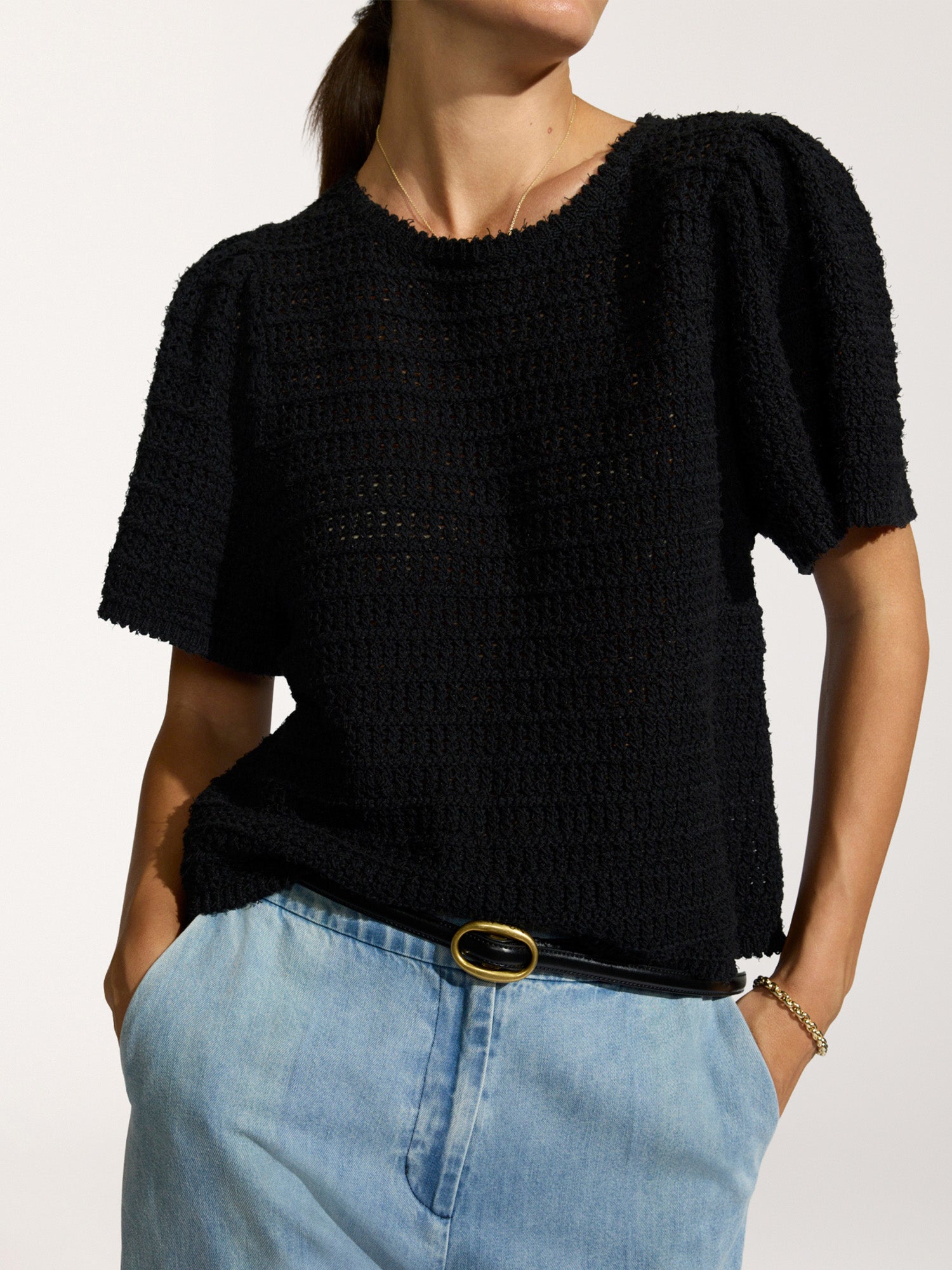Emerson textured knit top in black with puff sleeves, worn with light wash jeans and a black belt