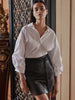 Black faux-leather mini skirt with tie-waist detail, styled with a white blouse