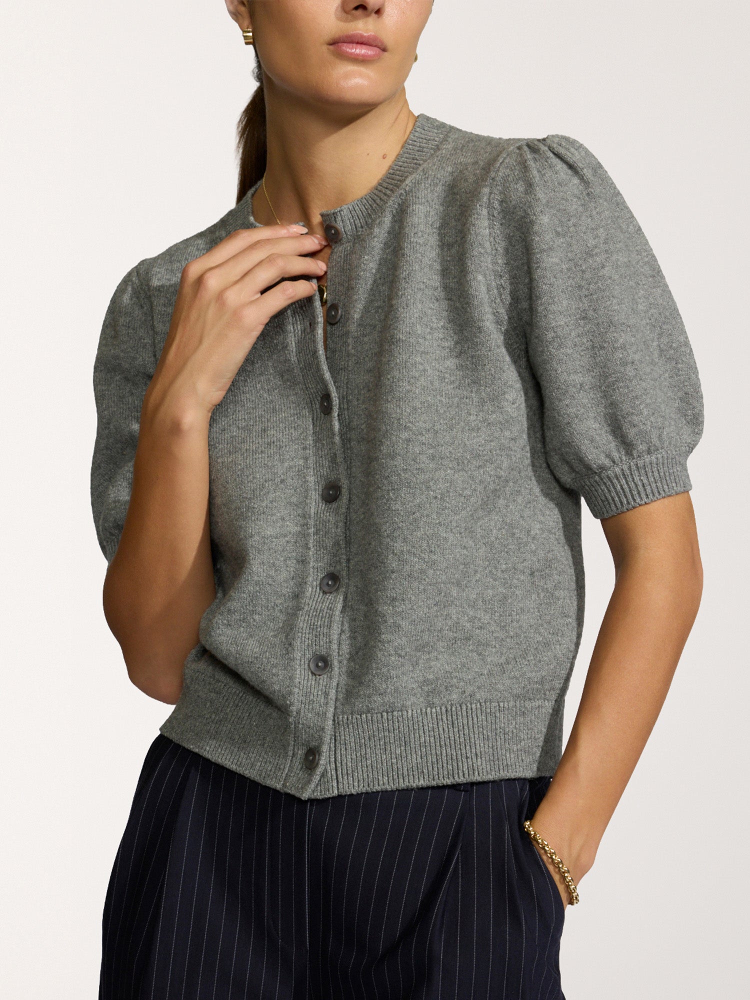 Havana short-sleeve knit cardigan in grey with puff sleeves, worn with navy pinstripe trousers