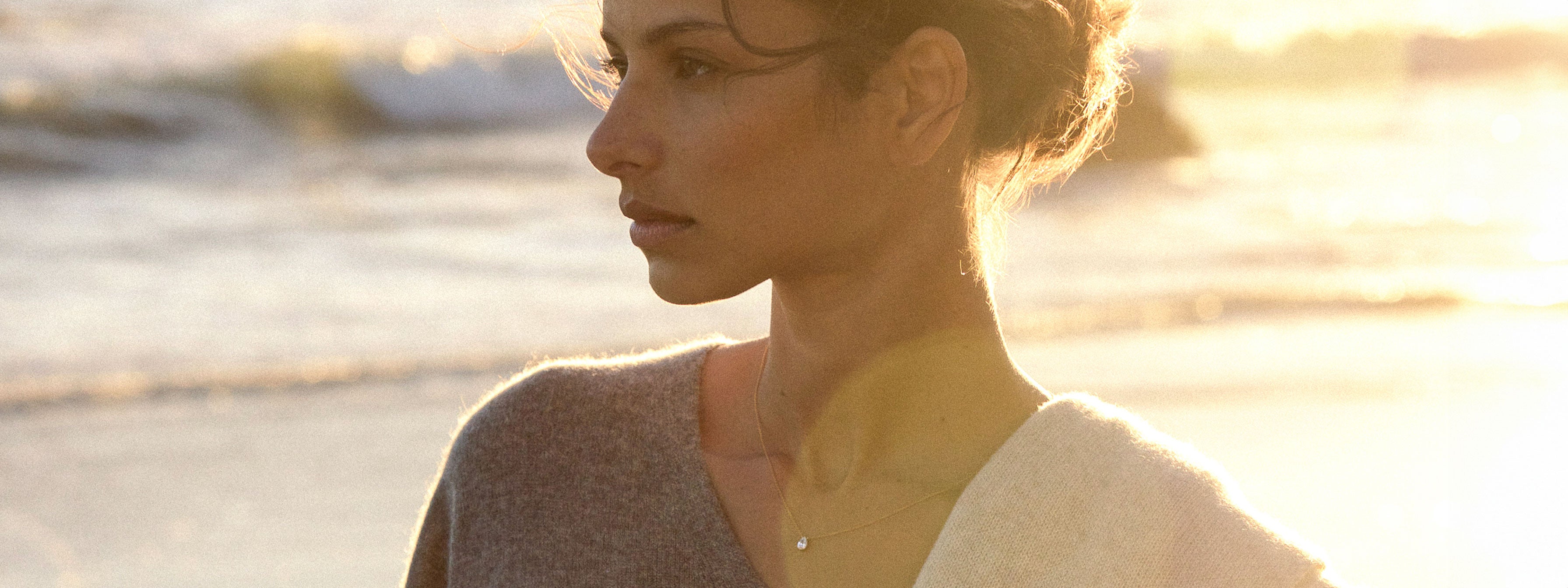 model standing in front of the beach wearing brochu walker's pendant