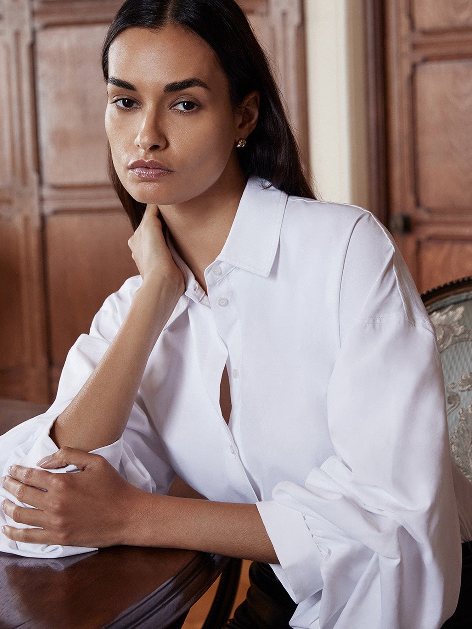 White button-up shirt with voluminous balloon sleeves, close-up seated portrait