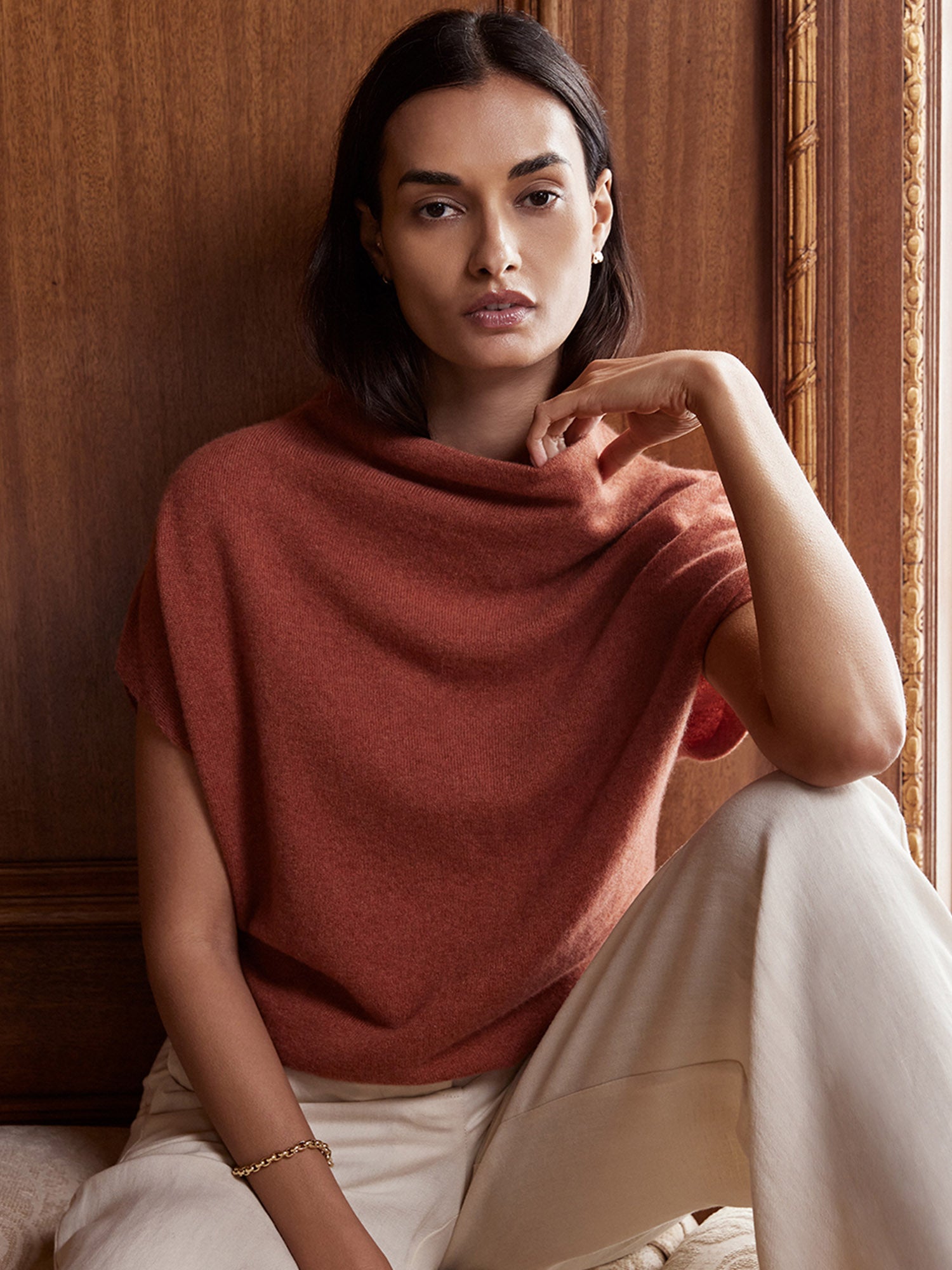 Woman wearing the Morten women's cashmere sweater in rust with cream trousers