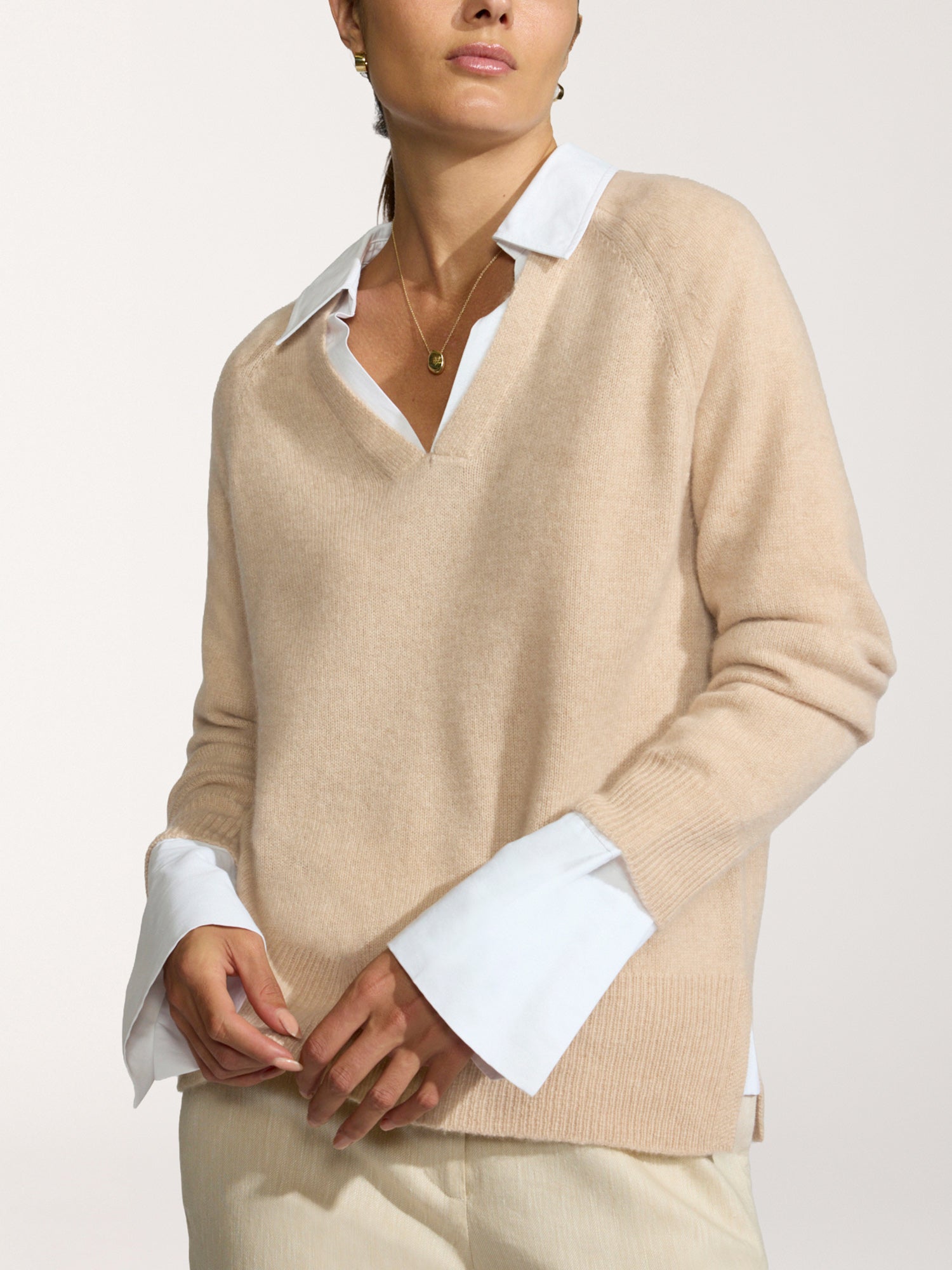 Ella layered pullover in camel worn over a white collared shirt with matching cream trousers