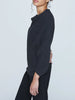 Side view of charcoal ribbed cashmere sweater with cowl neckline, styled with black trousers.