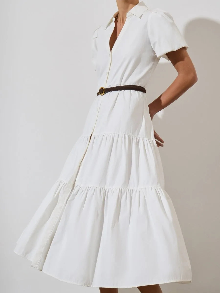 Side view of ivory tiered maxi dress with puff sleeves, v-neck collar, button front, and slim brown belt.