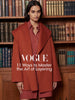 Woman wearing a rust-orange wool wrap coat, featured in a Vogue layering feature graphic